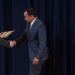 Doctor Potteiger shaking hands with an award recipient in a blue-grey suit